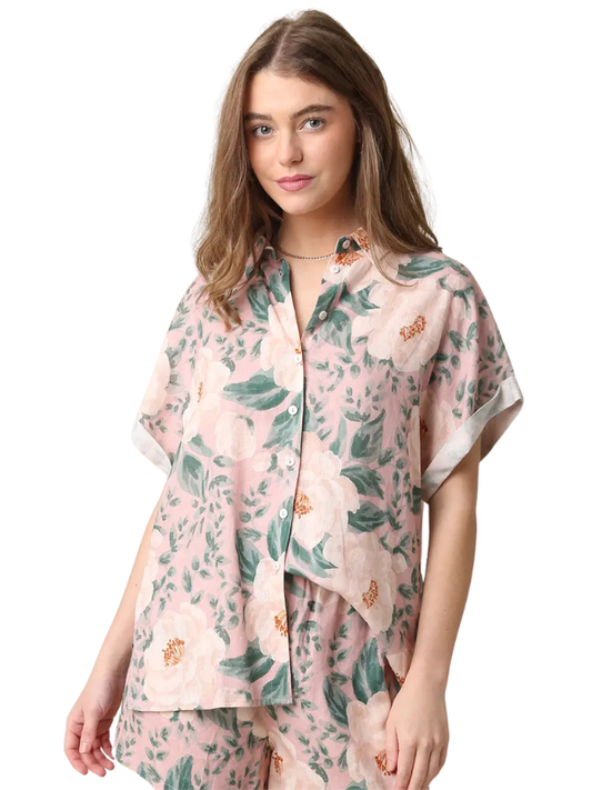 Woman wearing a pink floral pajama set on a white background