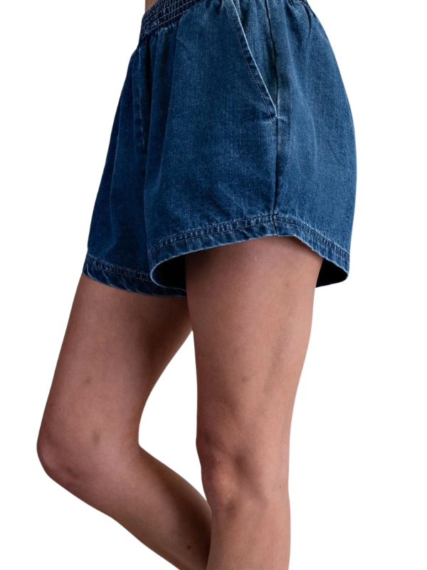 Blue denim shorts worn by a person on a white background
