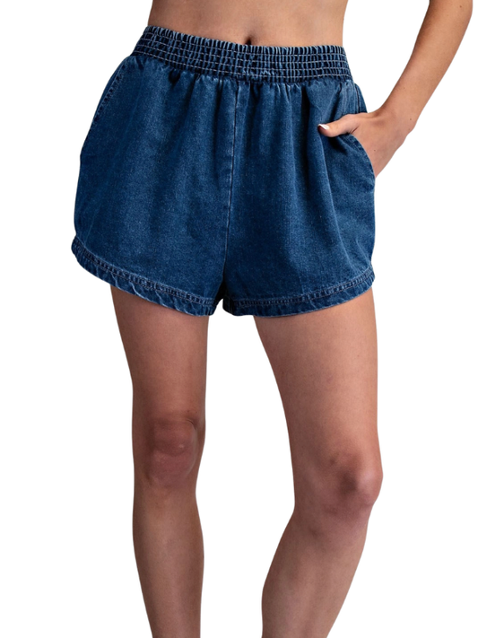 Blue denim shorts worn by a person on a white background