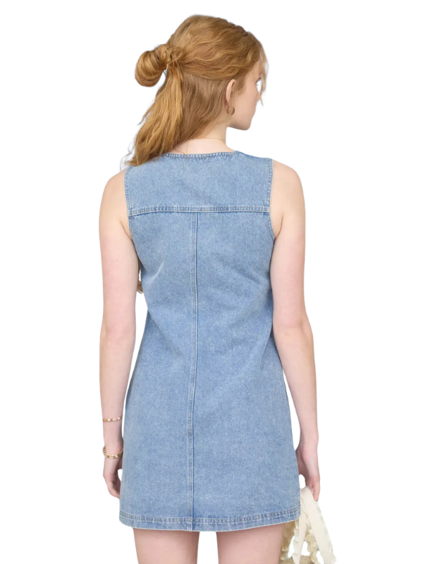 Woman wearing a light blue denim dress on a white background