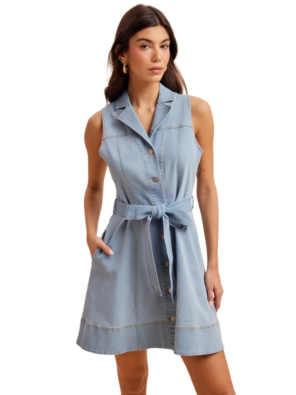 Woman wearing a light blue sleeveless dress with buttons on a white background