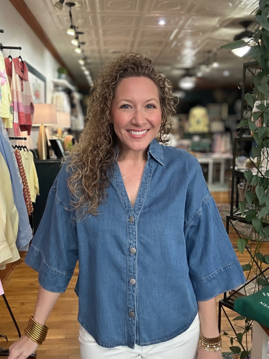 Woman wearing a blue denim shirt in a store setting