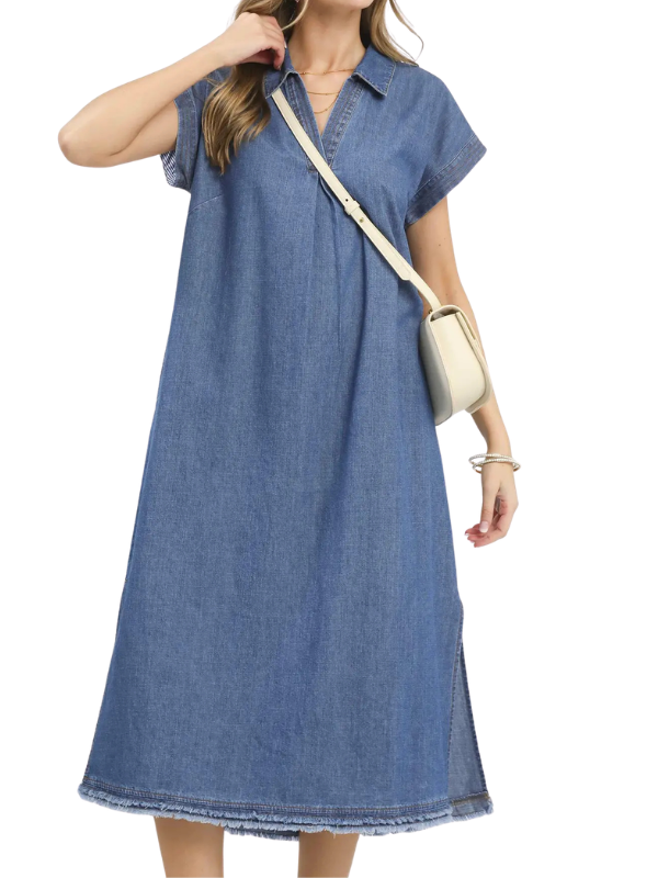 A woman wearing a short-sleeve denim midi dress with a collar and raw hem, styled with a cream crossbody bag against a white background.