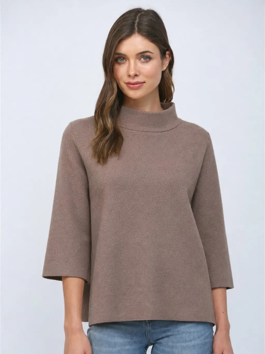 woman wearing a dusty brown sweater with jeans 
