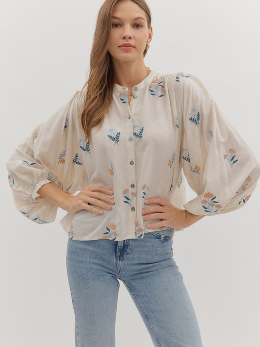 Woman wearing a floral blouse and jeans on a white background
