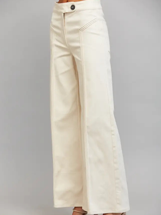 Cream wide-leg pants with a button closure and diagonal seam detailing, shown on a model from the waist down against a neutral gray background.