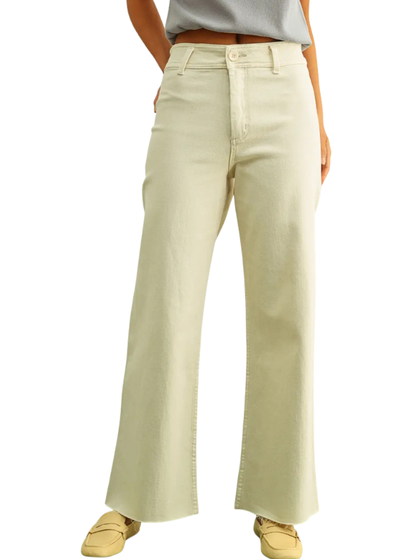 A person wearing light cream wide-leg jeans with a gray top and tan loafers, shown from the waist down on a plain white background.
