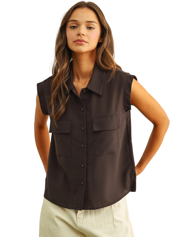 A woman modeling a sleeveless dark brown button-up shirt with two chest flap pockets, paired with light beige pants, against a plain white background.