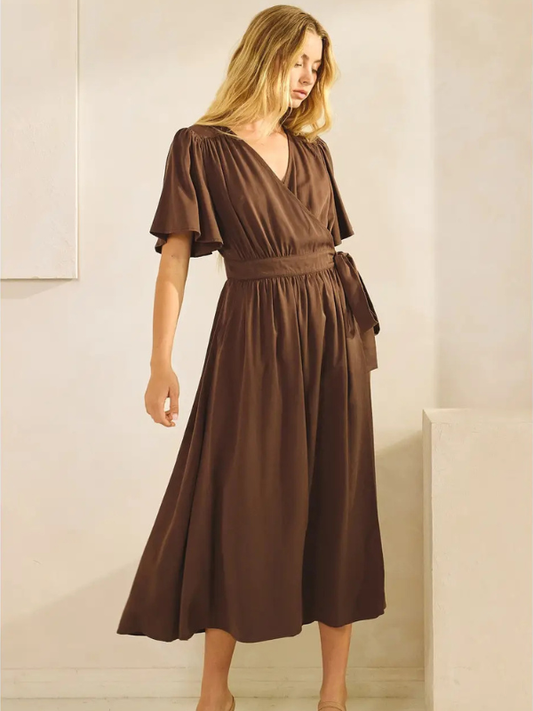 Woman wearing a brown dress in a minimalistic setting