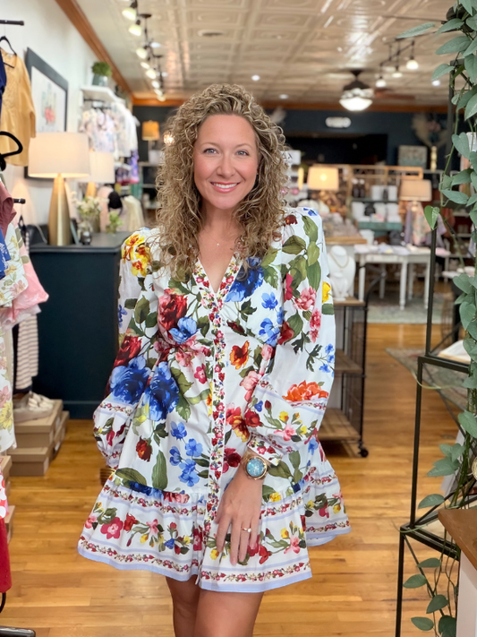 Woman wearing a colorful floral dress in a store setting