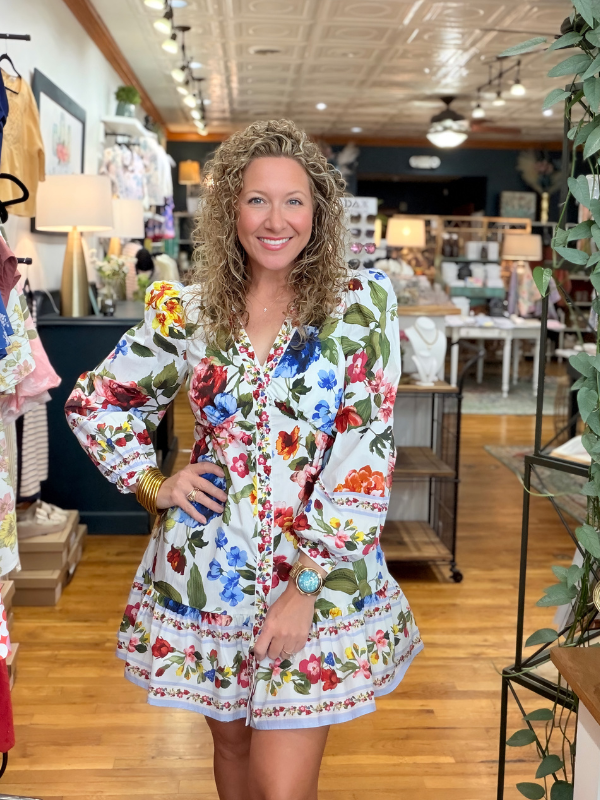 Woman wearing a colorful floral dress in a store setting
