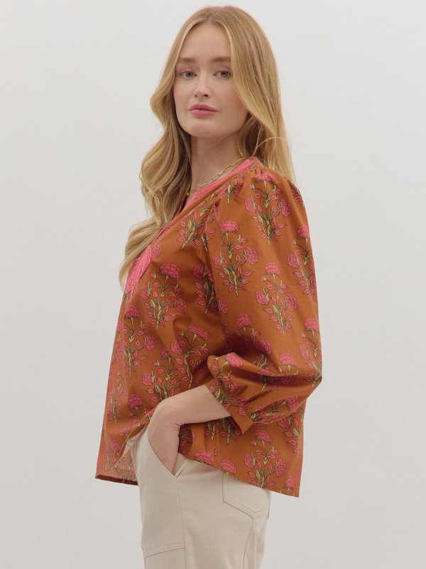 Woman wearing a floral blouse with a plain background