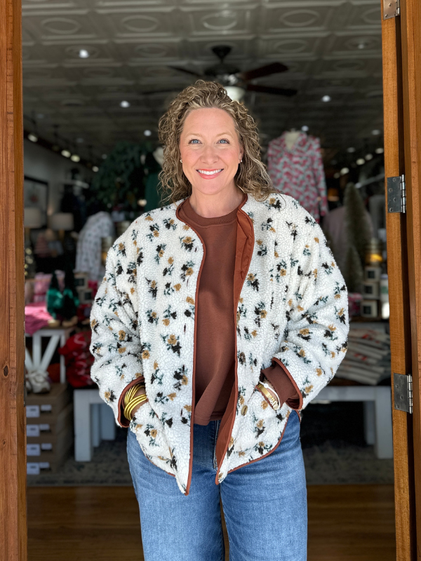 Woman wearing a floral jacket in a store setting