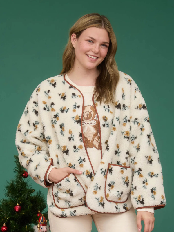 Woman wearing a floral patterned pajama set with a green background