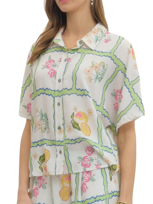 Woman wearing a floral and geometric patterned shirt on a white background