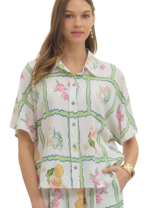 Woman wearing a floral and patchwork patterned blouse on a white background