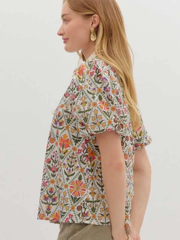 Woman wearing a floral blouse with a plain background