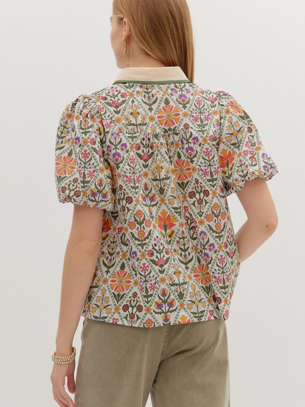 Person wearing a floral patterned shirt with a plain background