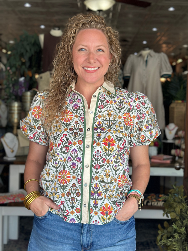 Woman wearing a colorful patterned shirt in a store setting