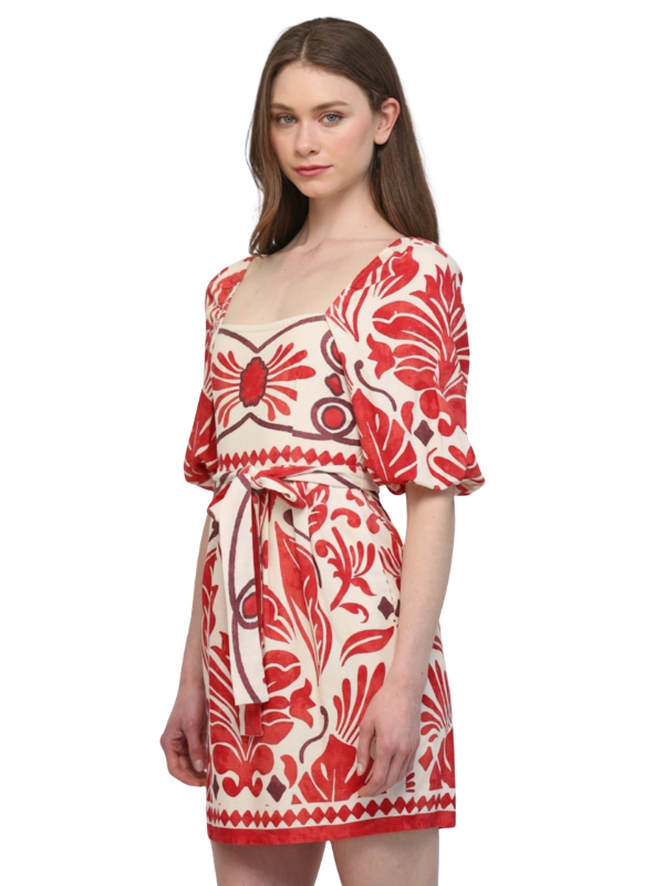 Woman wearing a red and white floral dress on a white background