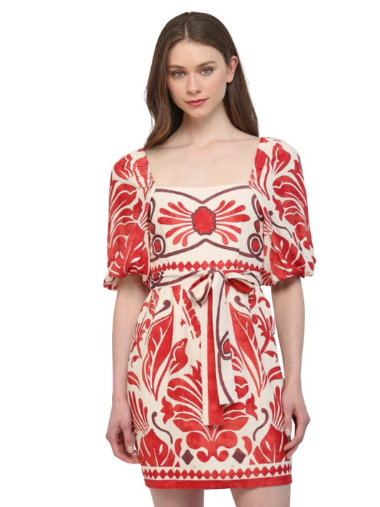 Woman wearing a red and white patterned dress on a white background