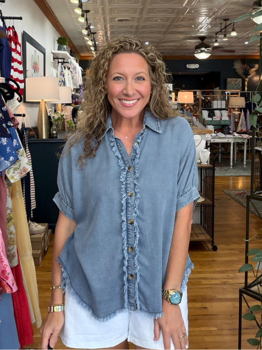 Woman wearing a blue denim shirt in a store setting