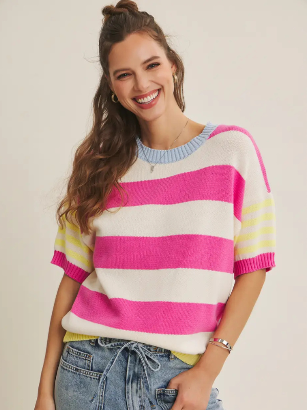 Woman wearing a colorful striped sweater with a plain background