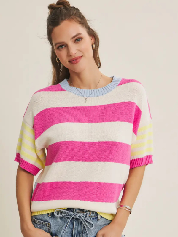 Woman wearing a colorful striped sweater on a plain background
