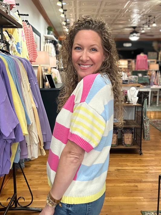 Woman wearing a colorful striped sweater in a store setting
