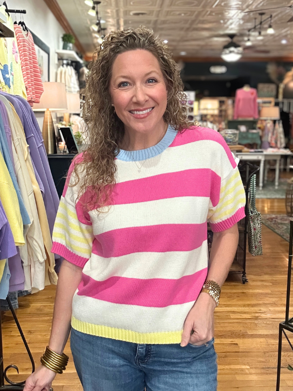 Woman wearing a colorful striped sweater in a store setting