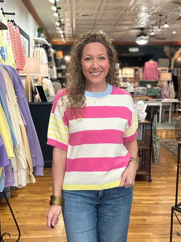 Woman wearing a colorful striped sweater in a store setting