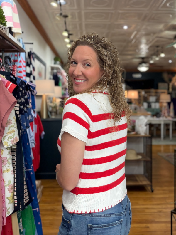 Woman wearing a red and white striped shirt in a clothing store.