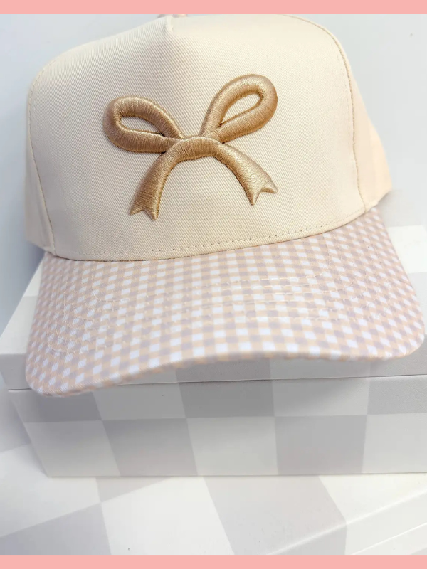 Beige cap with a bow design on a checkered background