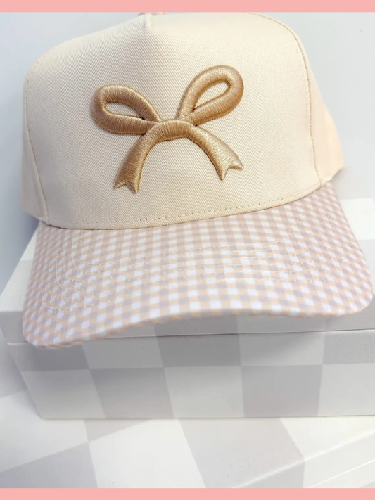 Beige cap with a bow design on a checkered background
