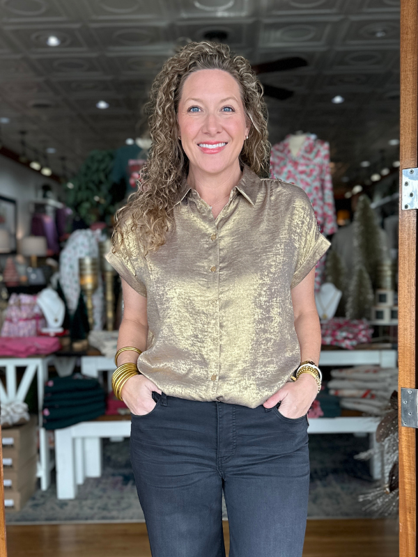 Woman wearing a gold metallic shirt in a store setting