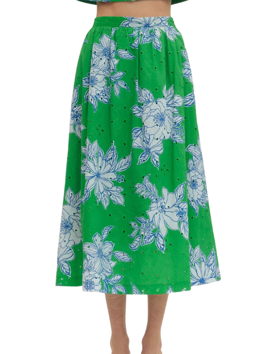 Green skirt with blue floral pattern worn by a person on a white background