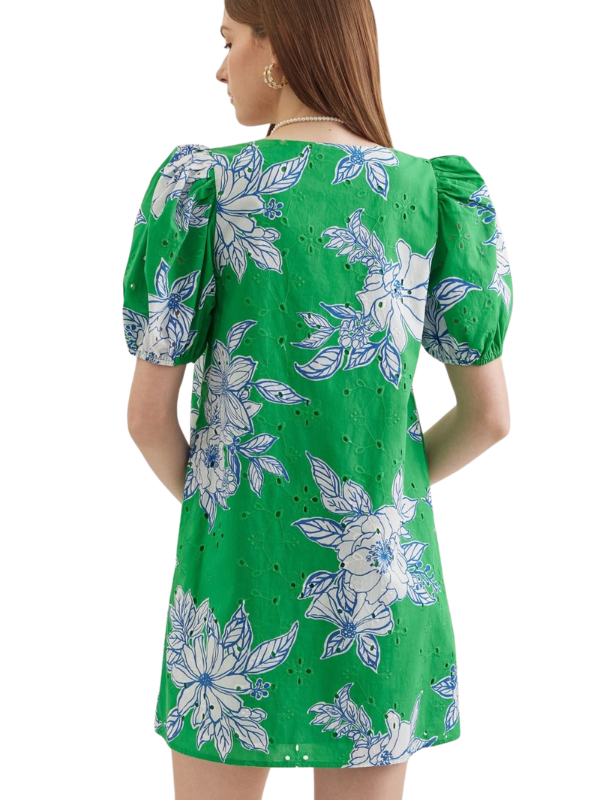 Green dress with floral pattern worn by a person on a white background