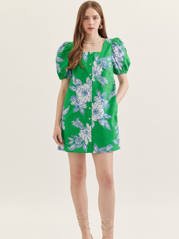 Woman wearing a green floral dress on a white background