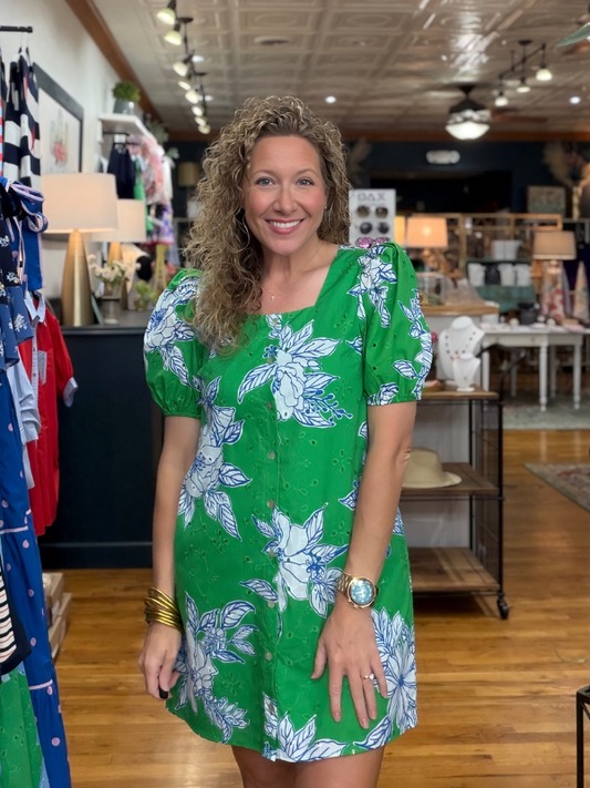 Woman in a green floral dress standing in a store