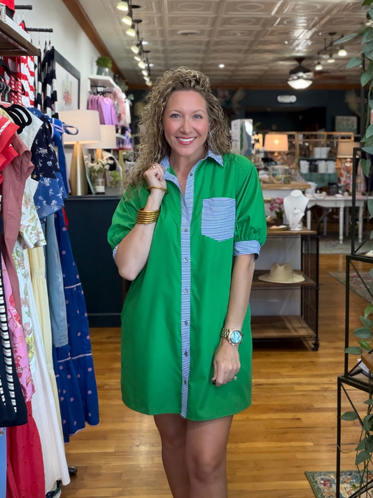 Woman in a green dress standing in a clothing store