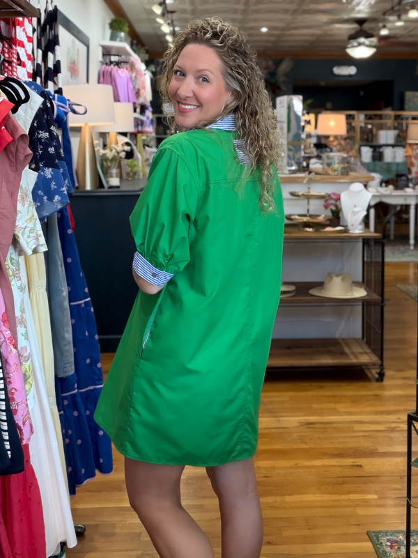 Woman wearing a green dress in a clothing store