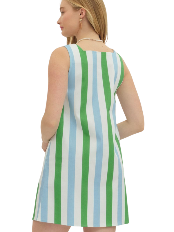 Woman wearing a sleeveless dress with green and blue stripes on a white background