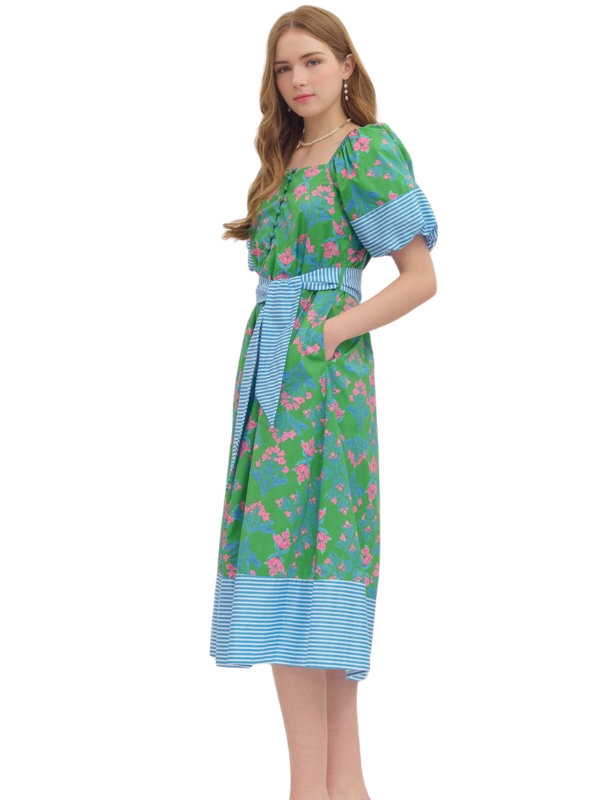 Woman wearing a floral dress with blue accents on a white background