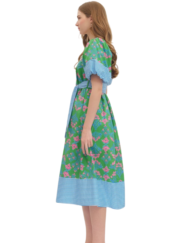Woman wearing a floral dress with blue accents on a white background
