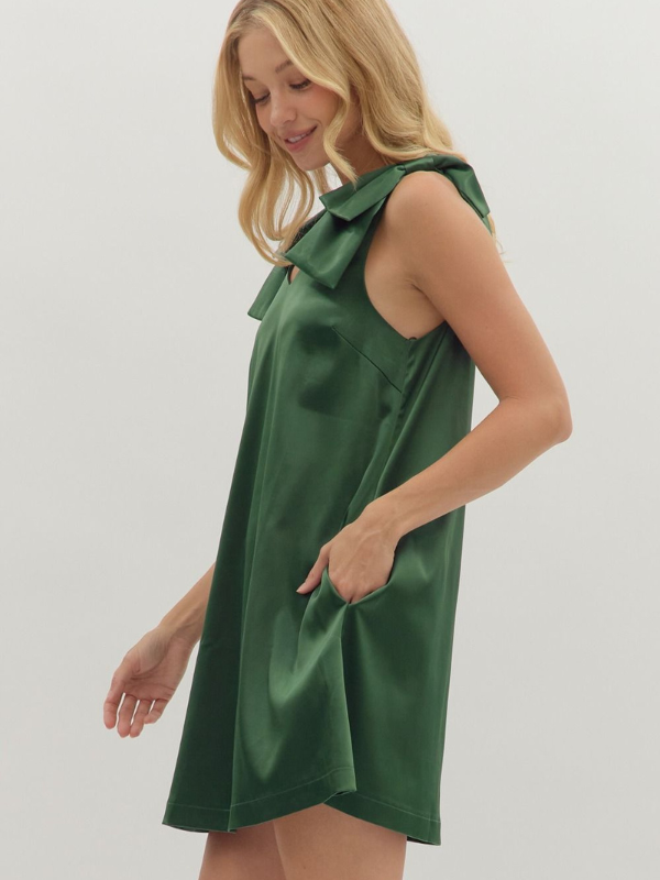 Woman wearing a green dress with ruffled shoulders on a white background