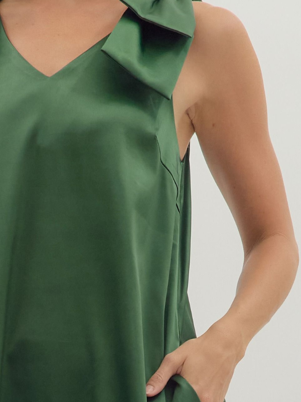 Green dress with a ruffled collar on a plain background