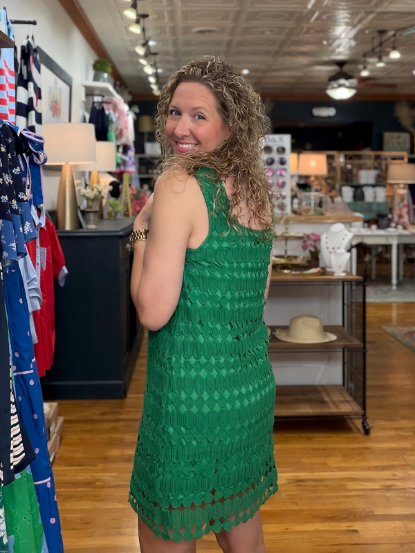 Woman wearing a green dress in a store setting