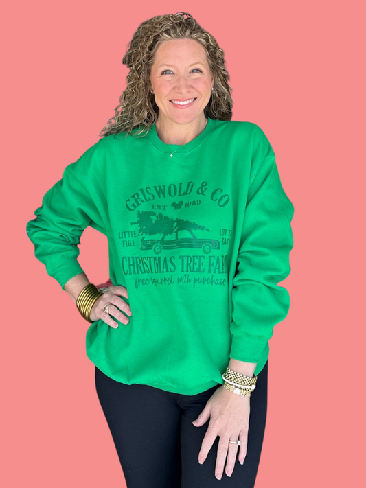 Woman wearing a green sweatshirt with text and graphics on a pink background