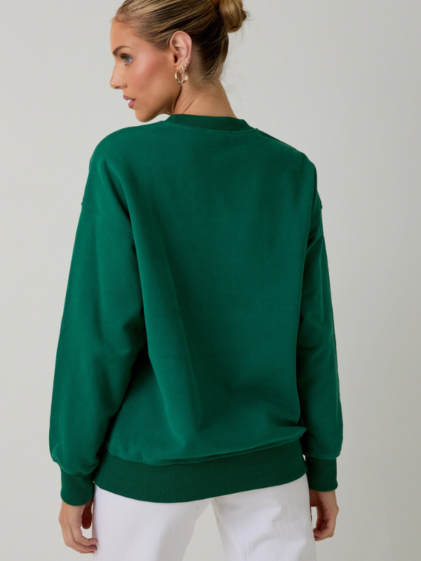 Person wearing a green sweatshirt on a plain background