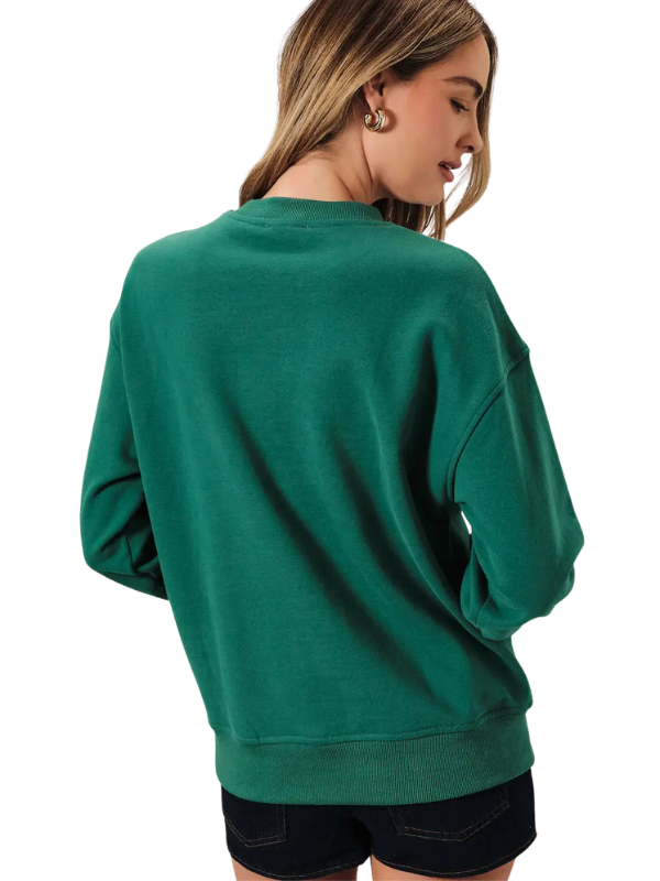 A woman wearing an oversized green crewneck sweatshirt, shown from the back against a plain white background.